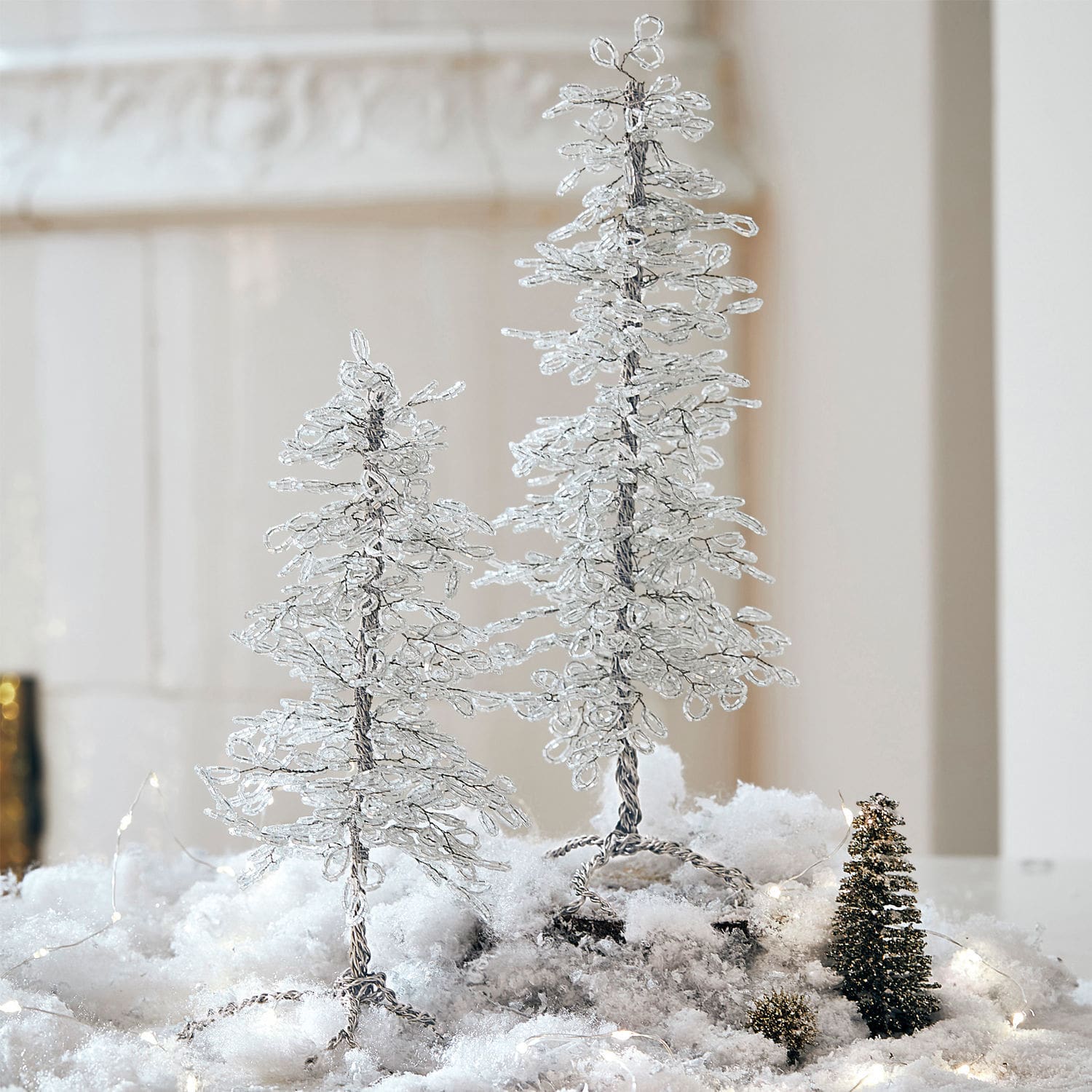Decoratieve draad- en kristalbomen op besneeuwde ondergrond voor winterse feestdecoratie