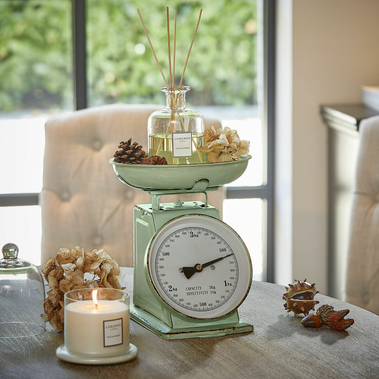 Keukenweegschaal Dorianza Mintgroene metalen keukenweegschaal met geur diffuser en kaars op houten tafel