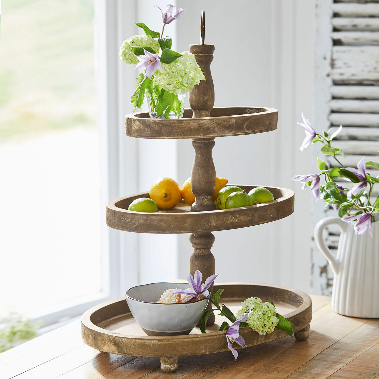 Etagère Olathe Houten drieledig etagère met fruit en bloemen op houten tafel in lichte kamer