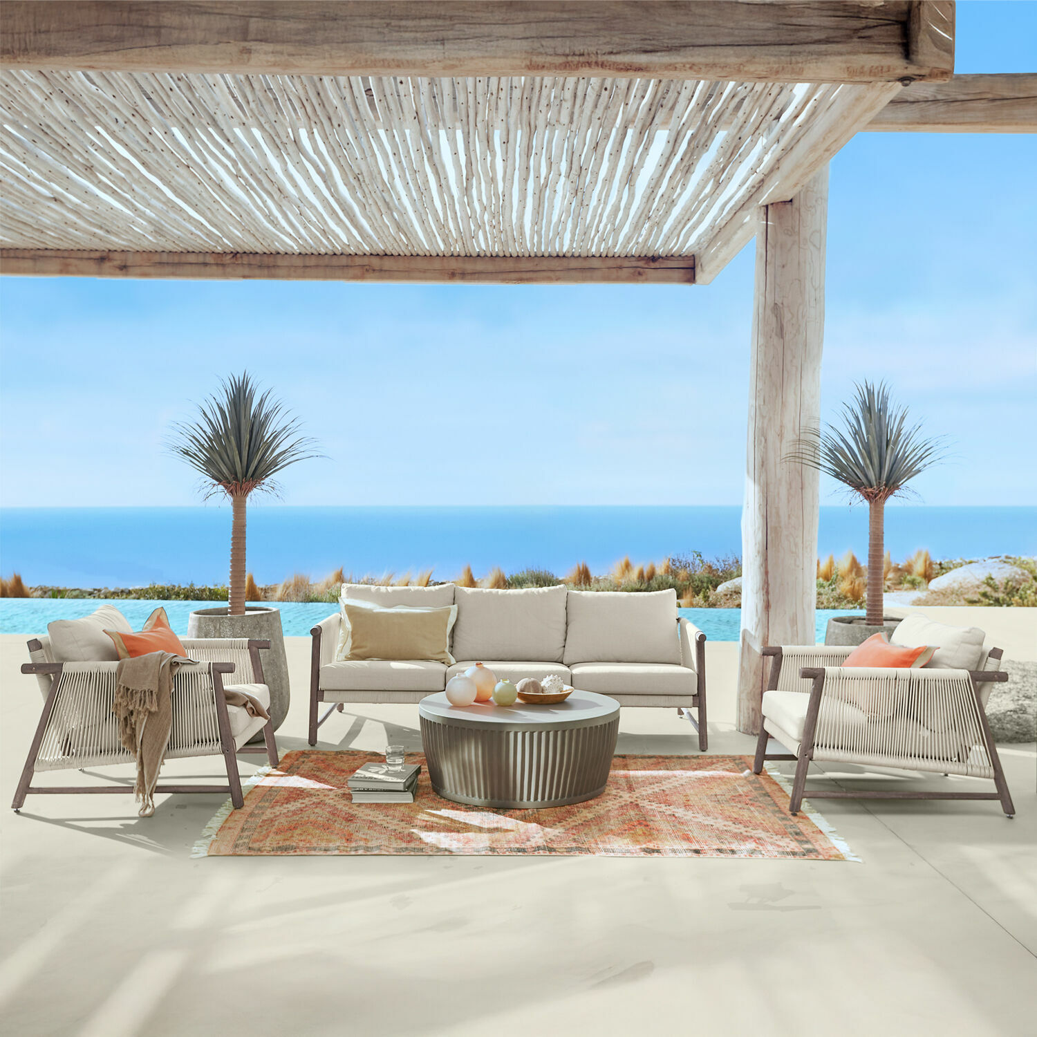 Salon de jardin FSC®-100% Clarmontaine Ensemble de mobilier d'extérieur avec coussins beige et cadre en bois sur terrasse avec vue sur mer